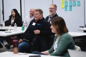 Photo of five adults looking forward in a classroom setting